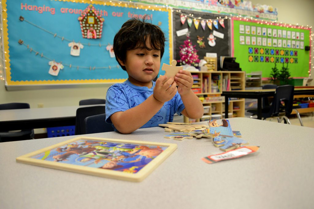 early childhood student puts together a puzzle